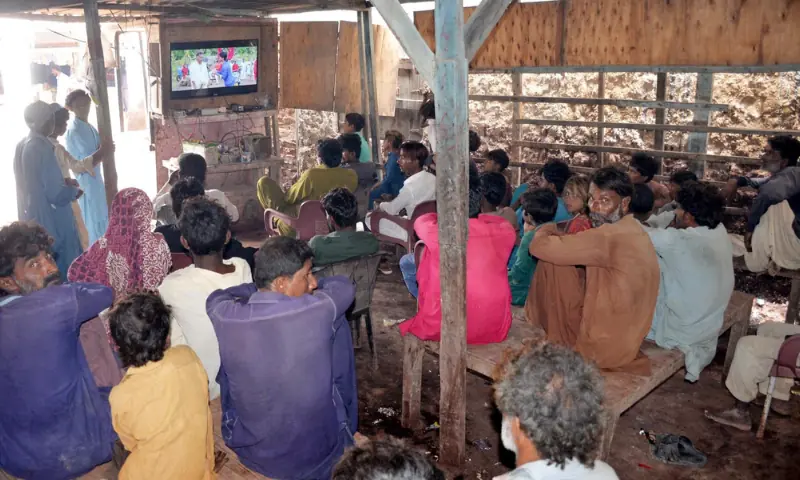 Residents watch a movie on television at one of the bazaar’s shops