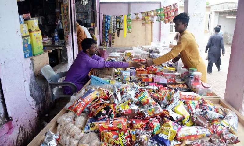 A customer buys candies at a shop in the bazaar