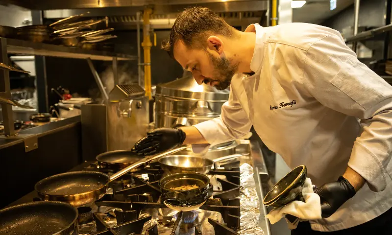 In this photo taken on November 12, 2025, Turkish chef Serhat Karanfil works in the kitchen of Woohoo, an artificial intelligence restaurant in Dubai. — AFP