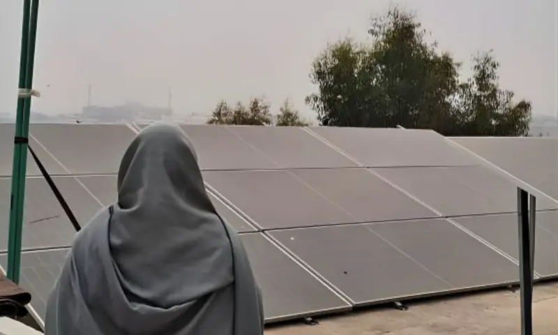  Zahida at her rooftop with the installed solar panels. 