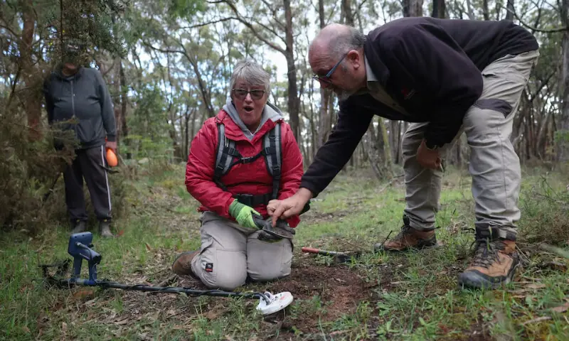 Vicki Plumridge, 63, a retired retail worker, reacts as Peter Vanjek, 65, a Gold and Relics prospecting tour guide, tells her she has found a small gold nugget during a Gold and Relics metal detector training session in Mount Doran, Australia, November 29, 2025. —  REUTERS