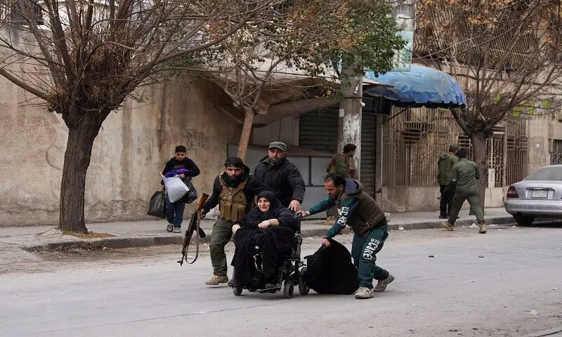 Members of the Syrian army help a woman as she flees following renewed clashes between the Syrian army and the Syrian Democratic Forces, in Aleppo, Syria, January 8, 2026. —Reuters