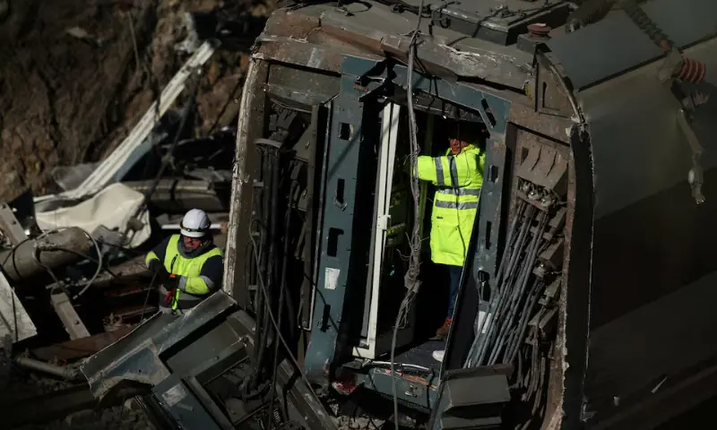   Maintenance workers from Adif work on the wreckage of a train involved in the accident, at the site of a deadly derailment of two high-speed trains near Adamuz, in Cordoba, Spain on January 20. &mdash; Reuters  