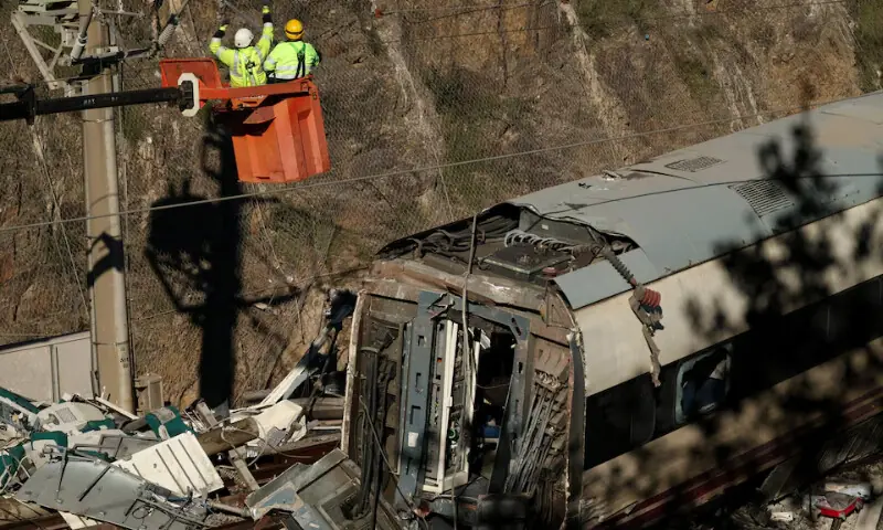   Maintenance workers from Adif work above the wreckage of a train involved in the accident, at the site of a deadly derailment of two high-speed trains near Adamuz, in Cordoba, Spain on January 20. &mdash; Reuters  