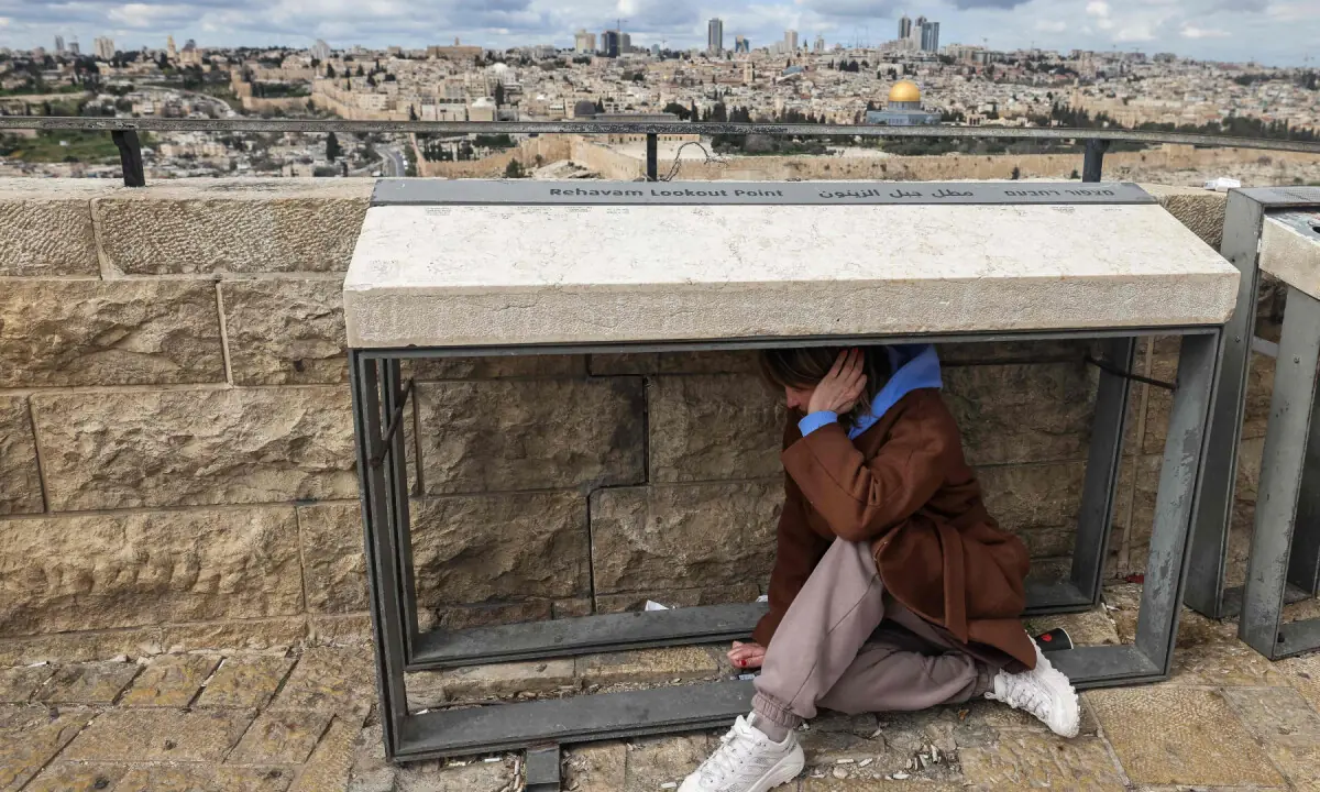 A person takes shelter as sirens sounded in Jerusalem on February 28, 2026, following the announcement that Israel had launched a &ldquo;preemptive strike&rdquo; on Iran.