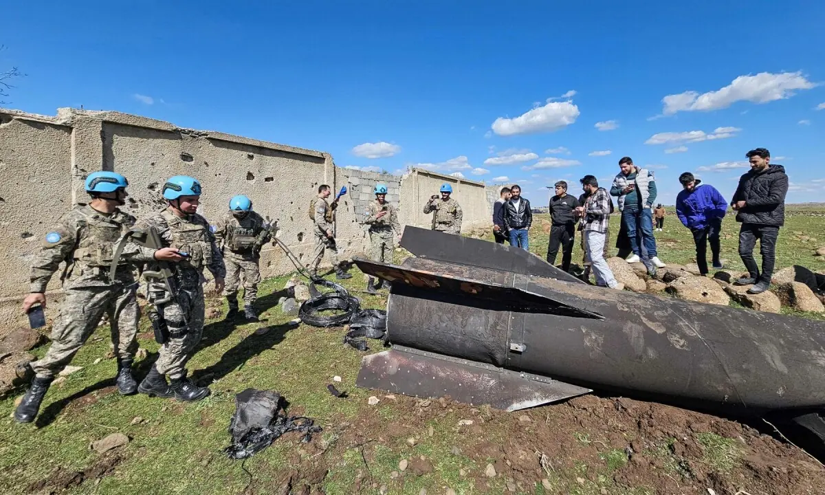 United Nations peacekeepers and civilians stand near the wreckage of an Iranian rocket that was reportedly intercepted by Israeli forces in the southern Syrian countryside of Quneitra, near the Golan Heights, close to the town of Ghadir al-Bustan. &mdash; AFP