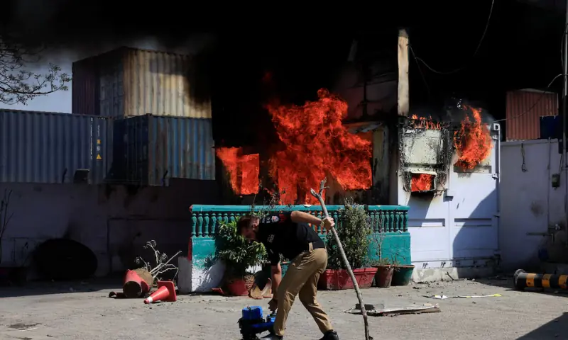 A police officer retrives items in front of a police checkpost burned by protesters near the U.S. Consulate General, following news of US and Israeli strikes on Iran that killed supreme leader Ayatollah Ali Khamenei, in Karachi, Pakistan March 1, 2026. Reuters/Akhtar Soomro
