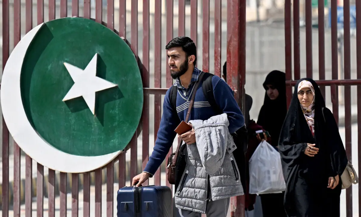 Pakistani nationals with their belongings walk across the Pakistan-Iran border at Taftan in Balochistan province on March 5, 2026, upon their arrival from Iran amid the Middle East war. &mdash; AFP