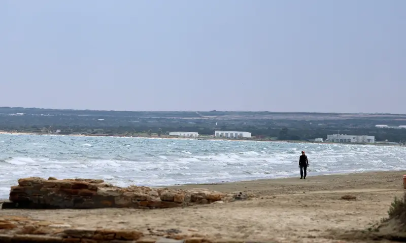A woman walks on a beach near RAF Akrotiri, a British sovereign base in Cyprus on March 7, 2026. &mdash; Reuters