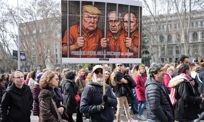 A man holds a banner mocking US President Donald Trump, Israeli Prime Minister Benjamin Netanyahu and Russia&rsquo;s President Vladimir Putin during a demonstration marking the International Women&rsquo;s Day in Madrid on March 8, 2026. &mdash; AFP