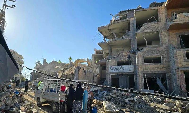 People stand by as civil defence members search through debris and rubble at the site of an Israeli airstrike on the village of Tayr Debba in southern Lebanon on March 9, 2026. — AFP