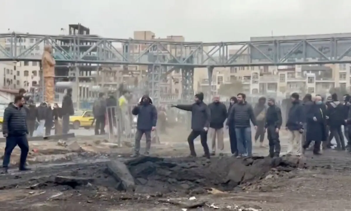 People stand at an affected area on the street, following a reported strike, amid the US-Israeli conflict with Iran, in Tehran, Iran, in this screengrab from a a handout video released March 10, 2026. &mdash; Iranian Red Crescent Society via Reuters