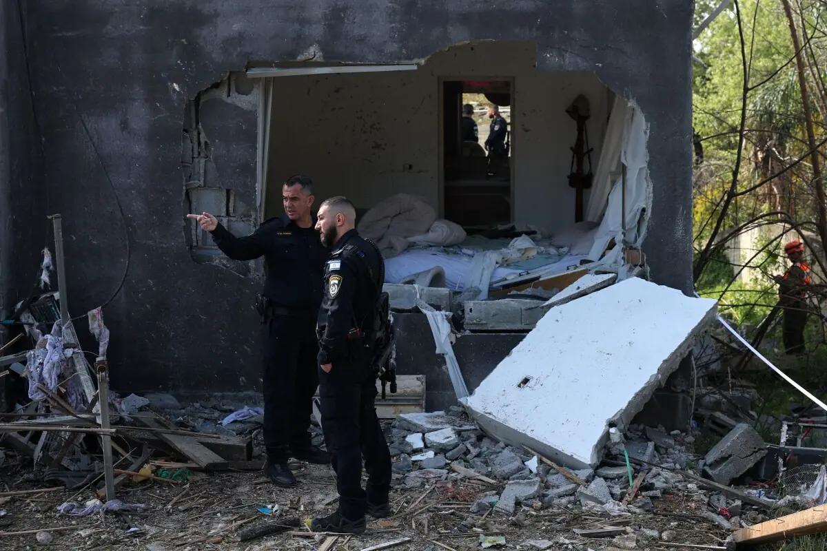 Israeli policemen inspect the site of a rocket strike in Zarzir, northern Israel, on March 13, 2026. &mdash; AFP