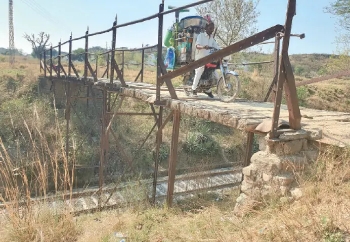  A street vendor travels over the wooden bridge on his motorcycle. &mdash; Photos by the writer 