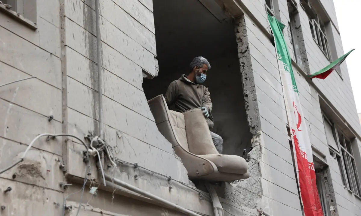 A man looks out of a house that was damaged by a strike, in Tehran, Iran on March 15, 2026. — WANA via Reuters