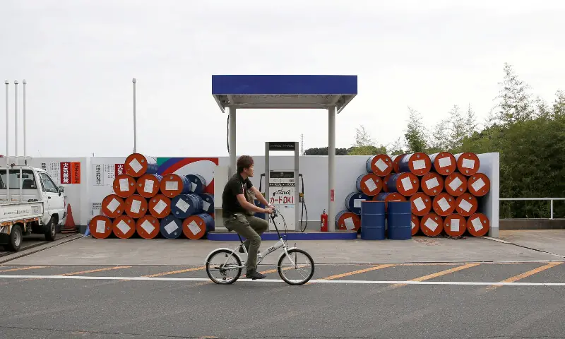 A man cycles past a Cosmo Oil’s petrol station of Suzuka Circuit in Suzuka, Japan on October 5, 2017. — Reuters/File