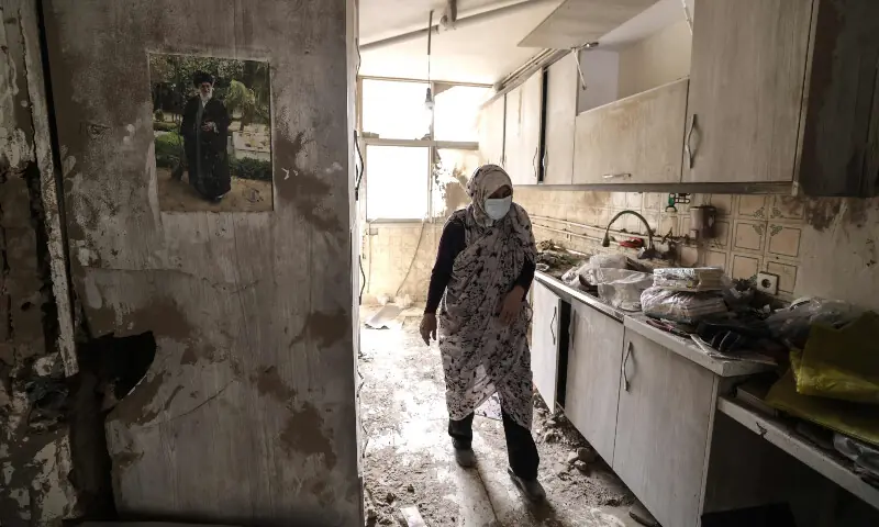 An Iranian woman walks through the destroyed kitchen in a home following a military strike in the Iranian capital Tehran on March 15, 2026.&mdash; AFP