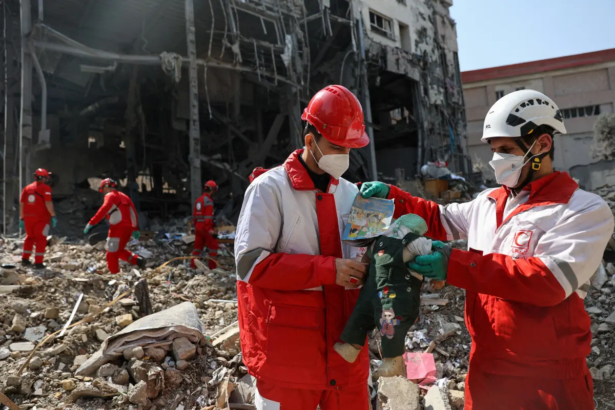 Members of a Red Crescent rescue team hold a doll, at the site of a building that was damaged by a strike, amid the US-Israeli conflict with Iran, in Tehran, Iran, March 17, 2026. &mdash; Reuters