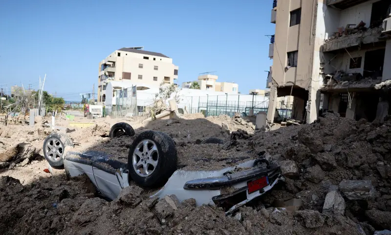 A car lies under debris at the site of a strike on a building in Burj el-Shamali, following an escalation between Hezbollah and Israel amid the U.S.-Israeli conflict with Iran, in Tyre, Lebanon on March 18, 2026. — Reuters