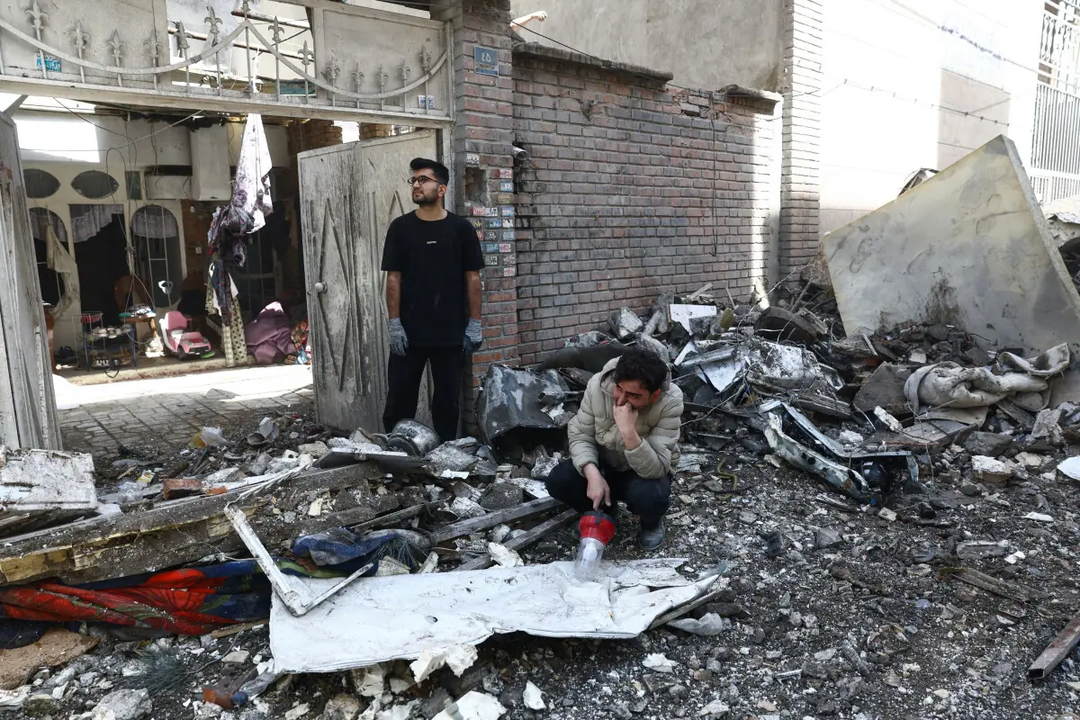 People react at the site of a residential building damaged by a strike, amid the US-Israeli war on Iran, in Tehran on March 27, 2026. &mdash; Reuters