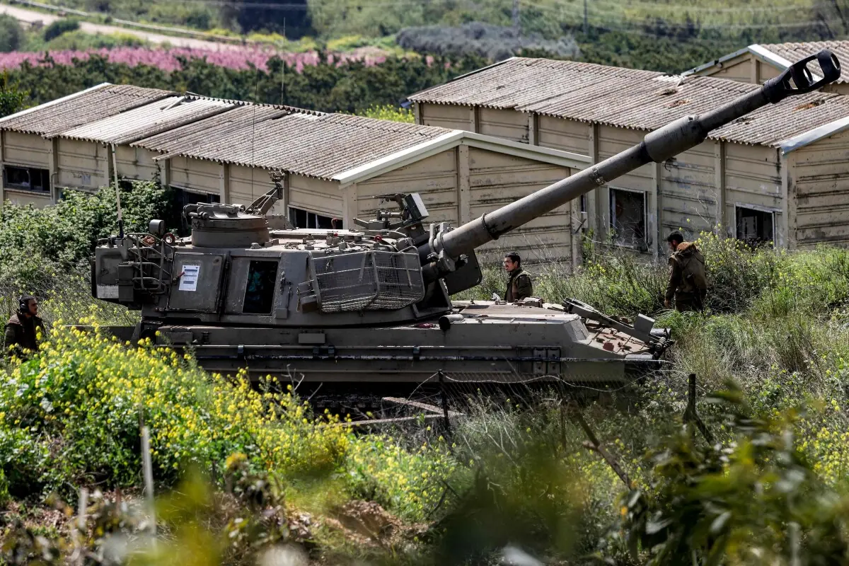 Israeli army soldiers stand next to a self-propelled Howitzer artillery gun positioned in the upper Galilee in northern Israel near the border with southern Lebanon on March 27, 2026. — AFP