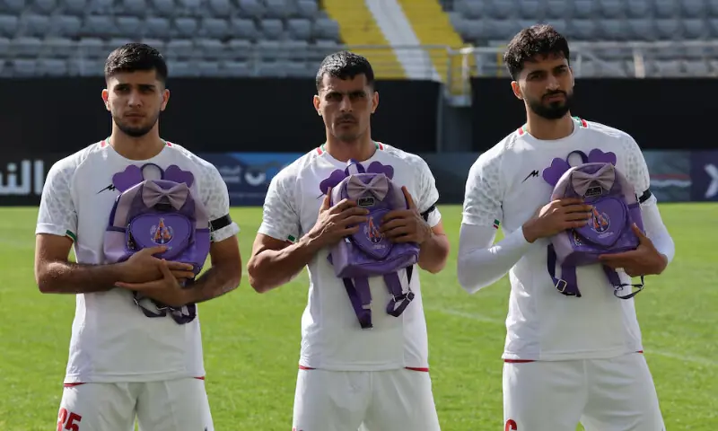 Iran players line up before the match as school bags are laid in memory of the victims of the girls school bombing in Minab, Iran, March 27, 2026. &mdash; Reuters