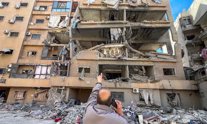 A man points at a building damaged by Israeli strikes, in Beirut&rsquo;s southern suburbs, Lebanon on March 28, 2026. &mdash; Reuters