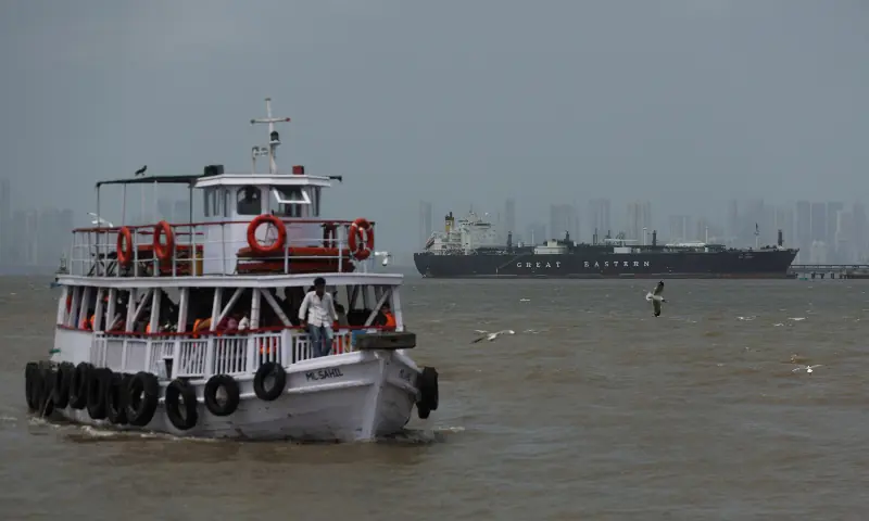 A ferry moves past the Jag Vasant vessel transferring LPG at a port after transiting the Strait of Hormuz amid supply disruptions linked to the US-Israeli conflict with Iran, in Mumbai, India on April 1, 2026. &mdash; Reuters
