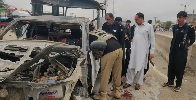  Police officials inspect the blast-hit van in Lakki Marwat on Tuesday. &mdash; Dawn  