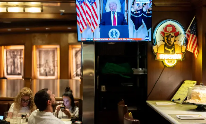 A customer watches US President Donald Trump address the nation on the Iran crisis from the White House in Washington, DC, on screen at Brooklyn Diner in Times Square, New York, US. — Reuters