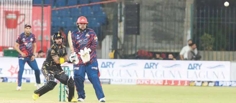  PESHAWAR Zalmi batter Kusal Mendis plays a shot as Karachi Kings wicket-keeper Azam Khan looks on during the Pakistan Super League match at the National Bank Stadium on Thursday.&mdash;Tahir Jamal/White Star 
