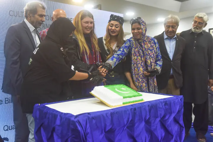 Gul-i-Afshan Tariq (second from left), adventure biker and solo traveller from the United Kingdom, cuts a cake, along with other women bikers, at the Quaid-i-Azam House Museum on Saturday. — Fahim Siddiqi / White Star