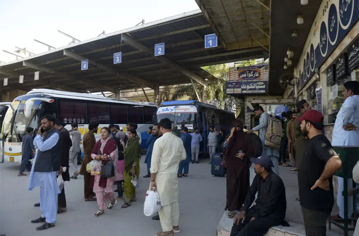   People wait for their bus at a terminal at Faizabad in Rawalpindi on Monday. The bus terminal reopened after remaining closed for four days as part of security measures taken for the Islamabad Talks between the US and Iran. &mdash; Photo by Mohammad Asim  