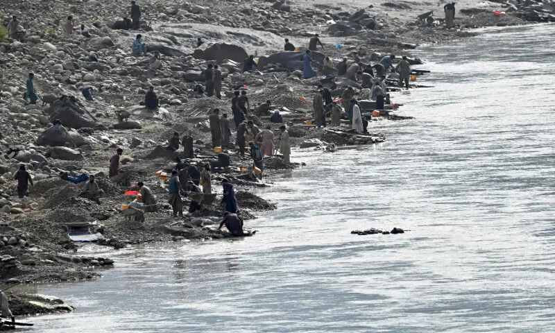 This photograph taken on April 13, 2026 shows Afghan men digging a mountainside along the Kunar riverbed before seiving stones in search of gold nuggets in the Song area of Ghaziabad district, Kunar province. &mdash; AFP