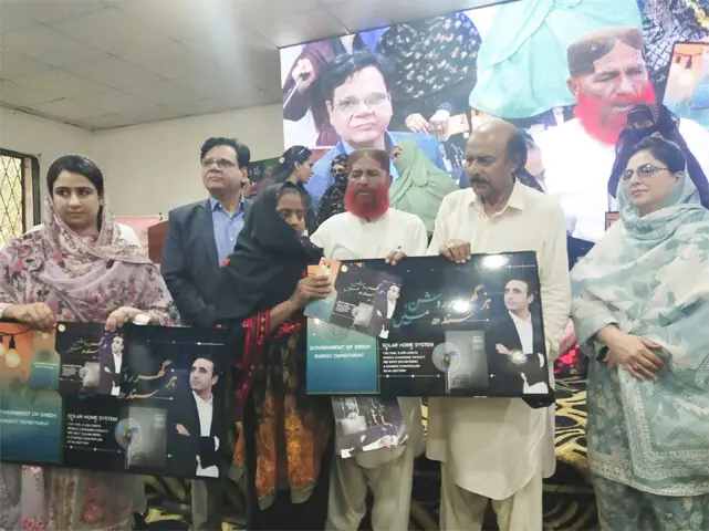  Nisar Khuhro distributes, along with others, solar panels in Qambar-Shahdadkot.&mdash;Dawn 