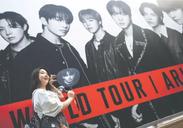  A BTS fan poses for in front of a poster at Tokyo Dome before the start of the band&rsquo;s world tour.&mdash;AFP 