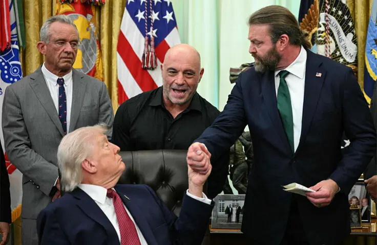   US Secretary of Health Robert F. Kennedy Jr. (left) and media personality Joe Rogan (centre) look on as President Donald Trump shakes hands with W. Bryan Hubbard, CEO of Americans for Ibogaine, during an executive order signing ceremony at the Oval Office.&mdash;AFP  