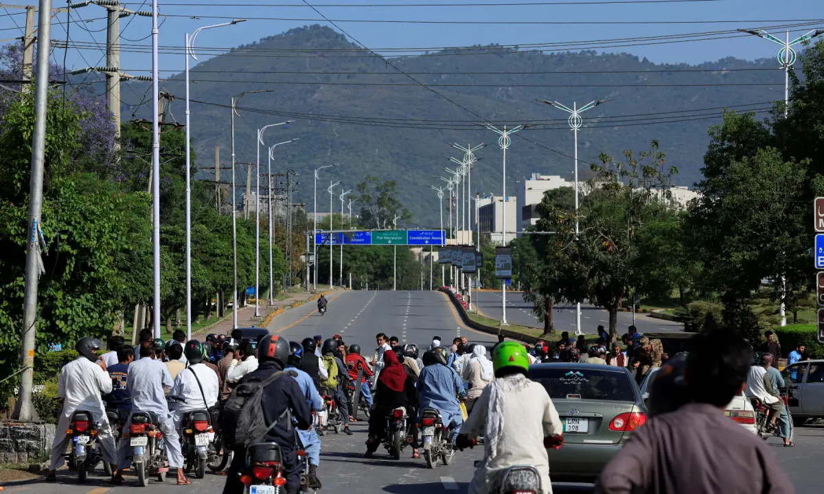 Commuters gather as police officers and Army soldiers divert the traffic on a road leading to the Serena hote in Islamabad on April 20, 2026. &mdash; Reuters