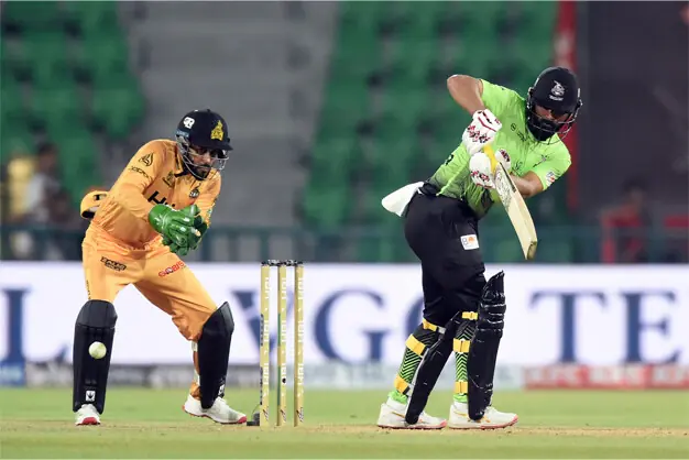  LAHORE Qalandars opener Fakhar Zaman plays a shot as Peshawar Zalmi wicket-keeper  Mohammad Haris looks on during the Pakistan Super League match at the Gaddafi Stadium on Saturday.&mdash;Murtaza Ali/White Star 