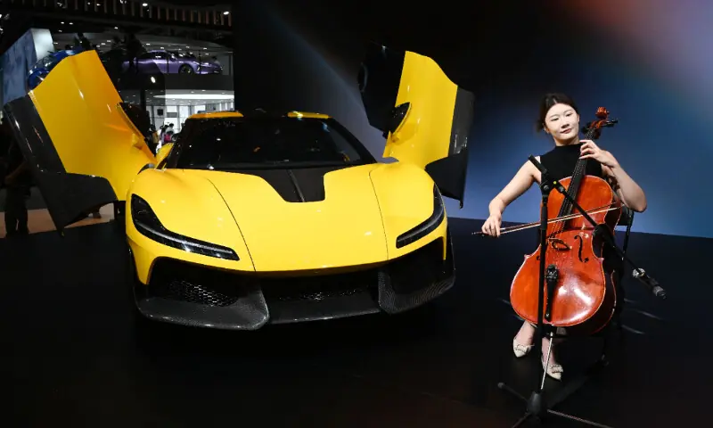 A musician plays next to a Dreame Nebula Next 01 concept car at the Beijing Auto Show in Beijing on April 26, 2026. &mdash; AFP