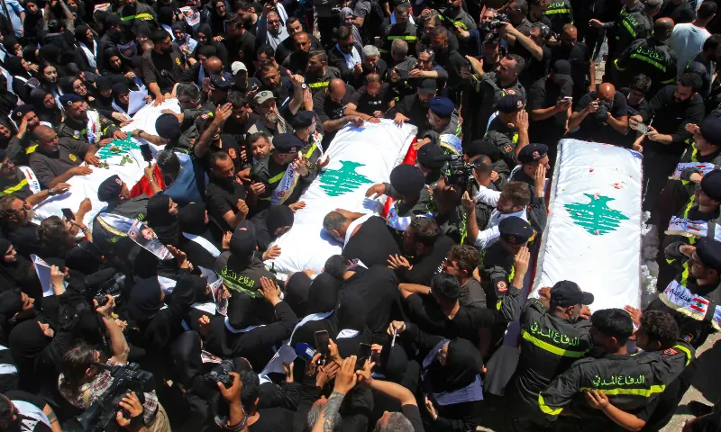Mourners gather around the coffins of three Lebanese Civil Defence members who were killed in an Israeli airstrike on the town of Majdal Zoun, during their funeral in the southern city of Tyre on April 30, 2026. &mdash; AFP