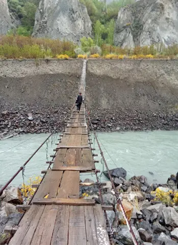  A villager crosses the suspension bridge in Upper Chitral. &mdash; Dawn 