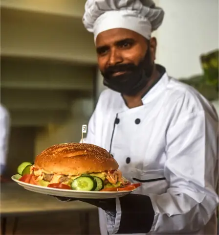  Chef Calvin John with his giant &lsquo;Godfather Burger&rsquo;. &mdash;Fahim Siddiqi / White Star  