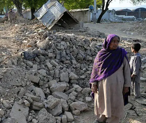  A woman stands in the rubble of her destroyed house in the Muslim Colony settlement of Islamabad, where demolitions began in December 2025 | AFP 