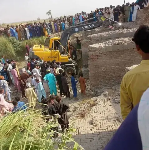 PEOPLE look on as efforts are under way to retrieve people from under the rubble on Friday.—Dawn