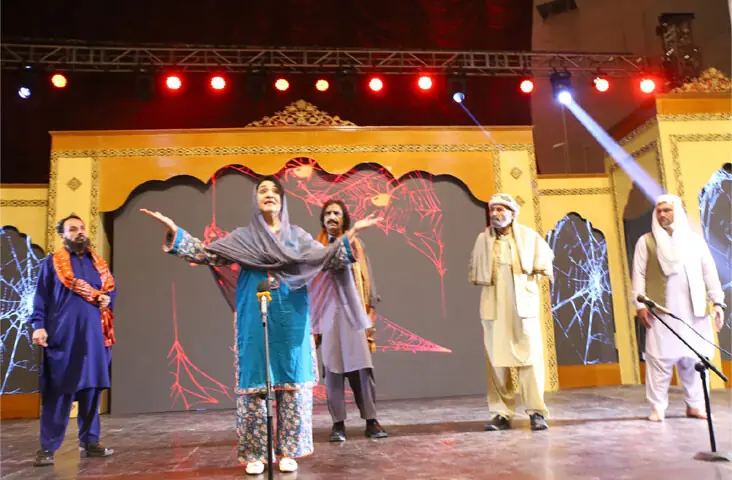  Artists stage &lsquo;Shehrag&rsquo; play at Nishtar Hall, Peshawar, on Sunday. (Right) Foreign tourists visit stalls at the Mela. &mdash; Dawn  