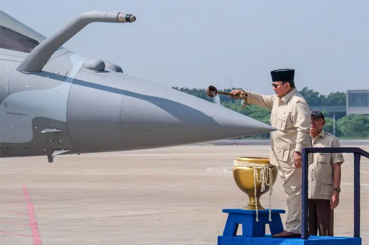 INDONESIAN President Prabowo Subianto splashes blessed water onto a Rafale fighter during a ceremony in Jakarta to hand over six new planes to the air force.—AFP