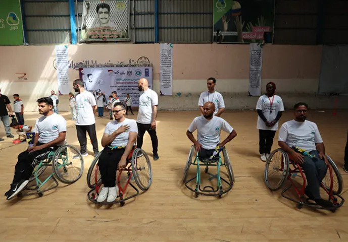 DIFFERENTLY-ABLED Palestinian players line up for the start of their basketball match, organised by an NGO at the Nuseirat Services Club, Gaza Strip.—AFP