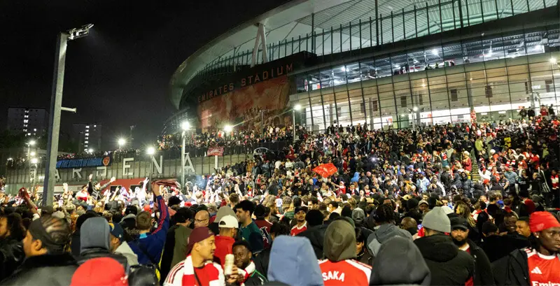 LONDON: Arsenal fans celebrate their team winning the Premier League title, outside the Emirates Stadium.—AFP