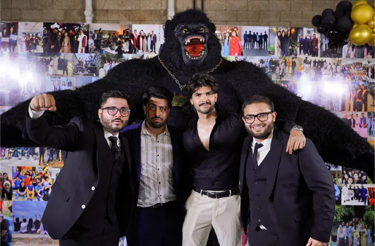 Medical school graduates pose with a performer in a gorilla costume at their farewell dinner in Karachi | FAS Events